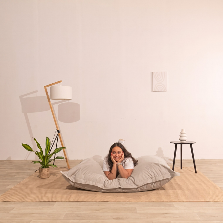 Personne allongée sur un pouf extérieur 140x180 cm dans un intérieur, démontrant son confort.