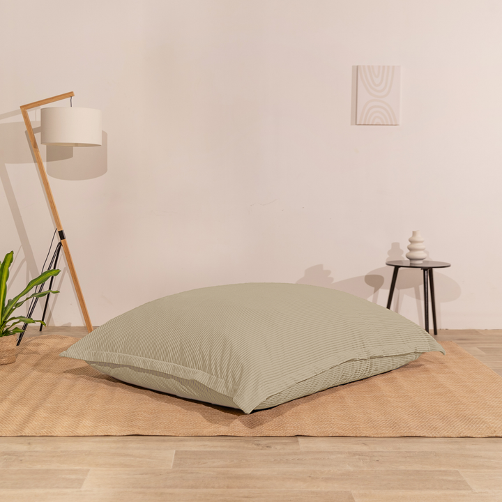 Pouf 140x180 cm en velours côtelé, assise moelleuse, posé à plat au sol dans un décor d&