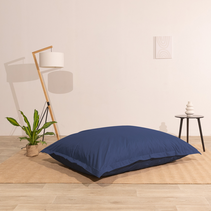 Pouf extérieur 140x180 cm installé dans un intérieur, utilisé comme assise au sol.