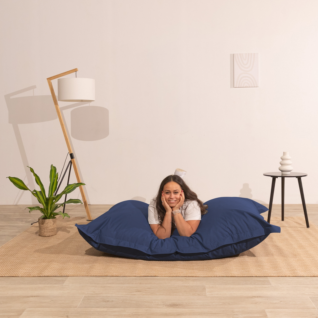 Personne allongée sur un pouf extérieur 140x180 cm dans un intérieur, démontrant son confort.