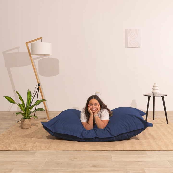 Personne allongée sur un pouf extérieur 140x180 cm dans un intérieur, démontrant son confort.
