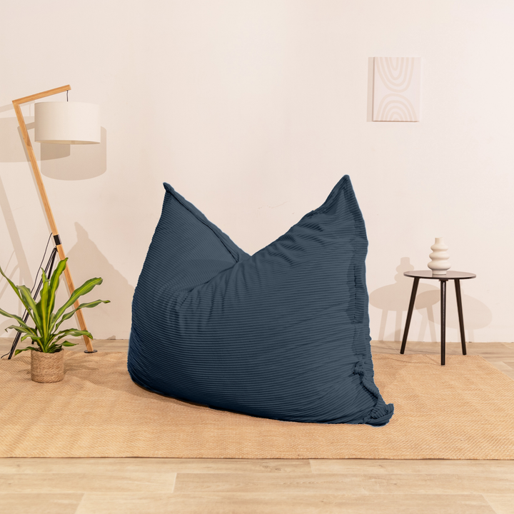 Pouf 140x180 cm en velours côtelé beige, posé au sol dans un décor d&