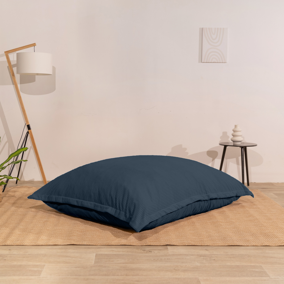 Pouf 140x180 cm en velours côtelé, assise moelleuse, posé à plat au sol dans un décor d&