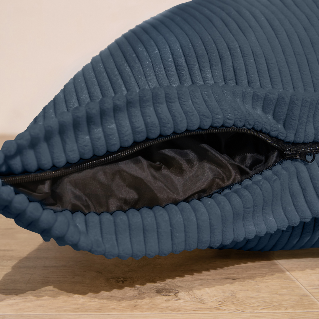Housse amovible du pouf en velours côtelé, fermeture éclair visible.