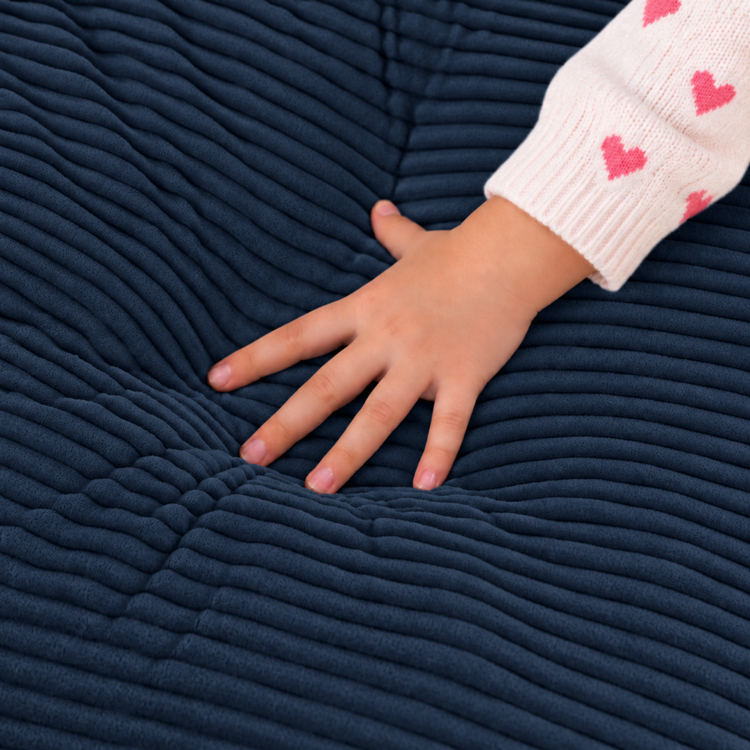 Pouf fauteuil enfant en velours côtelé bleu, texture côtelée et main sur l’assise