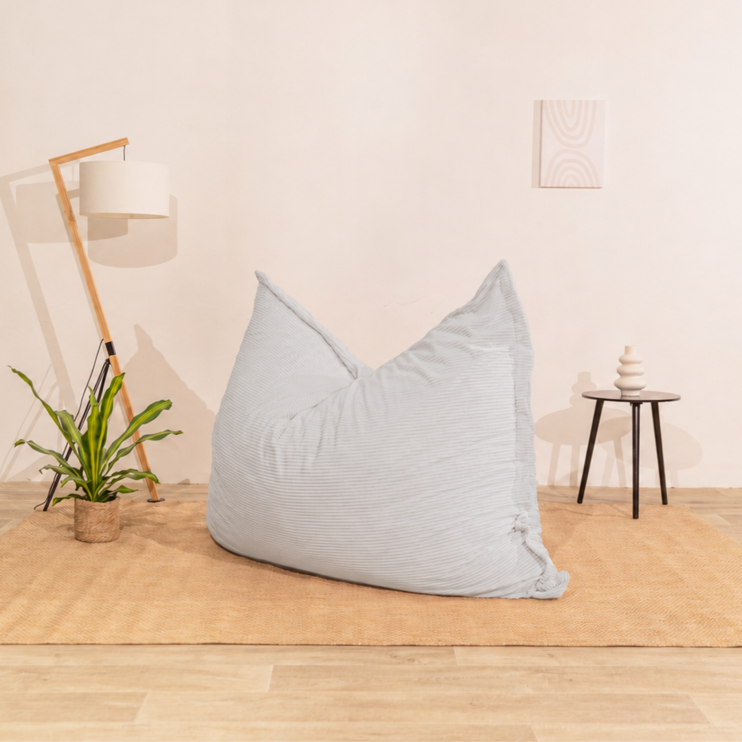 Pouf 140x180 cm en velours côtelé beige, posé au sol dans un décor d&