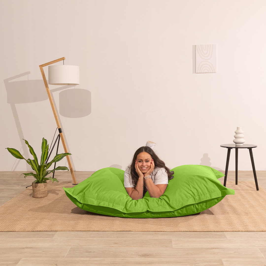 Personne allongée sur un pouf extérieur 140x180 cm dans un intérieur, démontrant son confort.