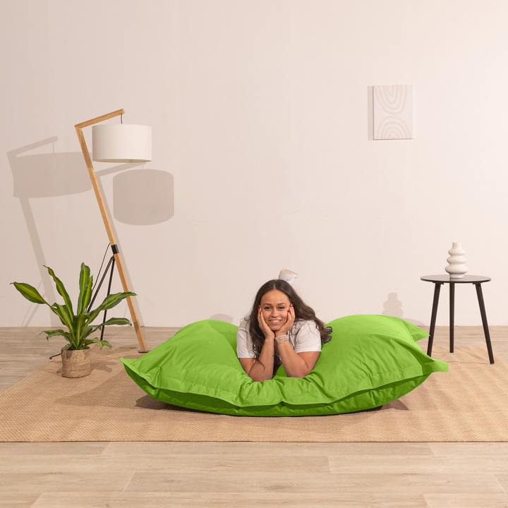 Personne allongée sur un pouf extérieur 140x180 cm dans un intérieur, démontrant son confort.