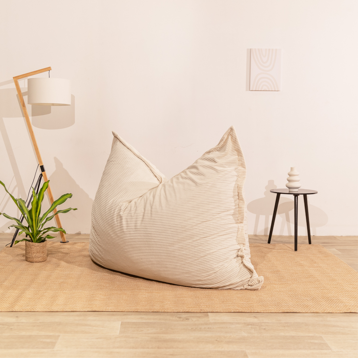 Pouf déhoussable velours côtelé blanc cassé, posé au sol dans un décor d'intérieur
