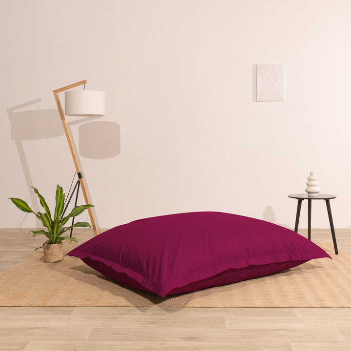 Pouf extérieur 140x180 cm installé dans un intérieur, utilisé comme assise au sol.
