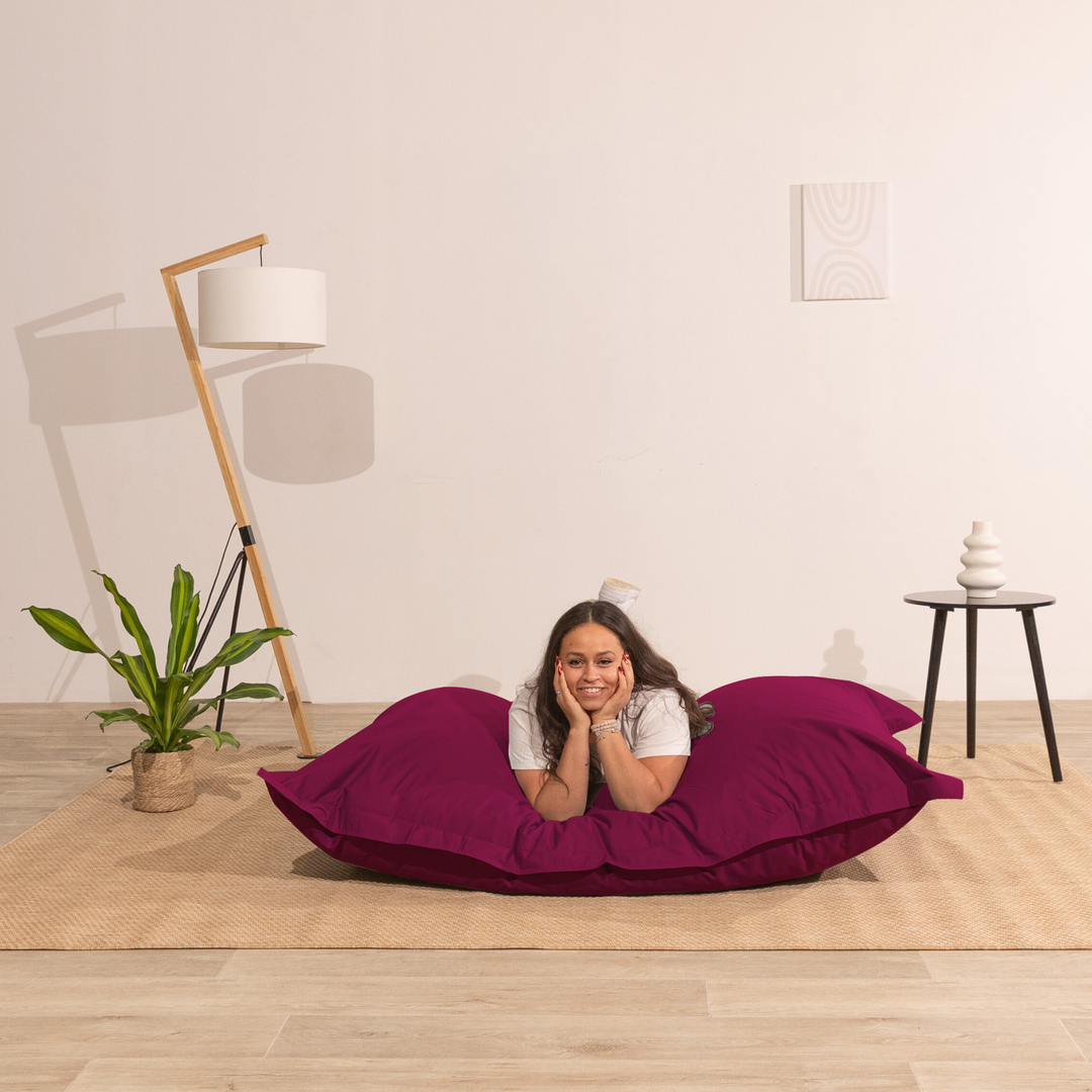Personne allongée sur un pouf extérieur 140x180 cm dans un intérieur, démontrant son confort.