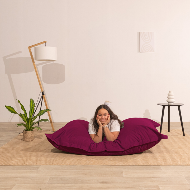 Personne allongée sur un pouf extérieur 140x180 cm dans un intérieur, démontrant son confort.