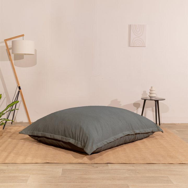Pouf 140x180 cm en velours côtelé, assise moelleuse, posé à plat au sol dans un décor d&