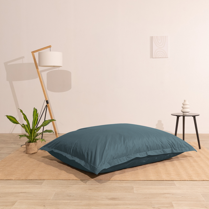 Pouf extérieur 140x180 cm installé dans un intérieur, utilisé comme assise au sol.