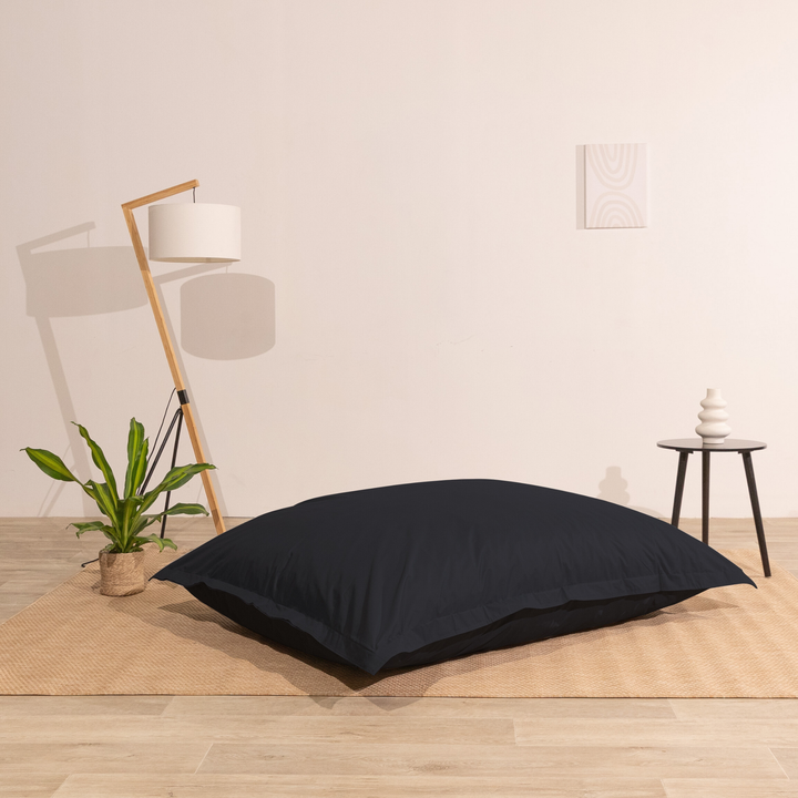 Pouf extérieur 140x180 cm installé dans un intérieur, utilisé comme assise au sol.