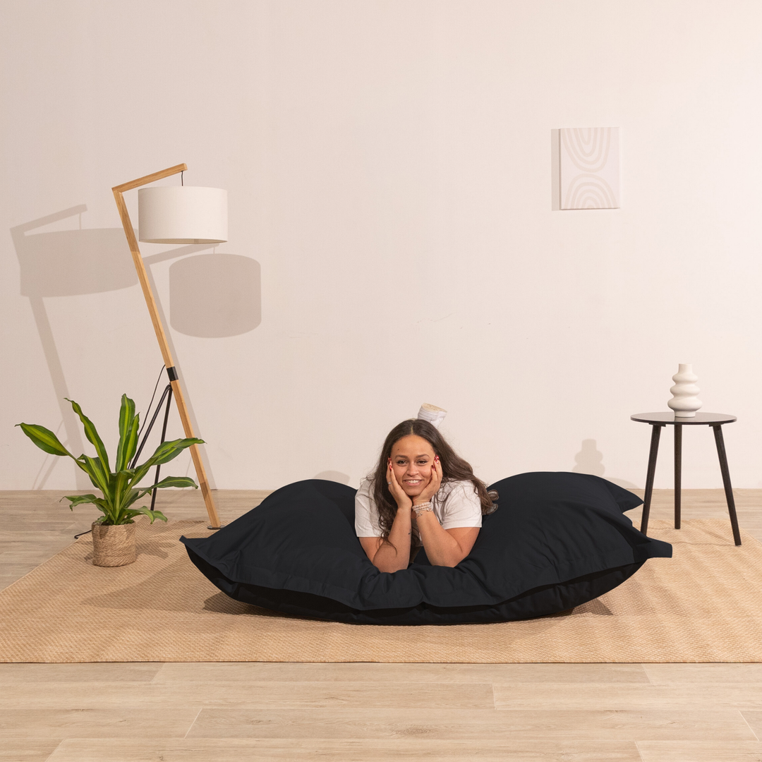 Personne allongée sur un pouf extérieur 140x180 cm dans un intérieur, démontrant son confort.