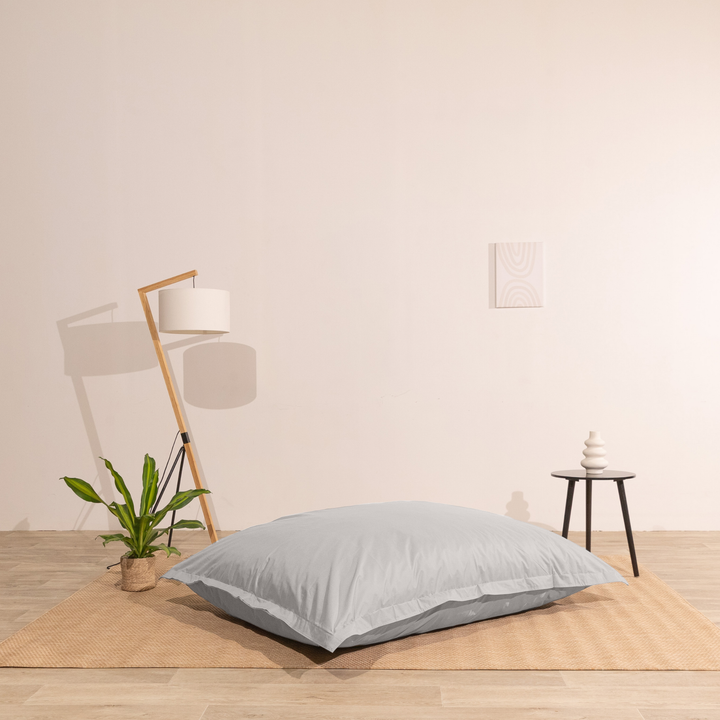 Pouf extérieur 140x180 cm installé dans un intérieur, utilisé comme assise au sol.