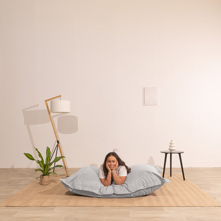 Personne allongée sur un pouf extérieur 140x180 cm dans un intérieur, démontrant son confort.