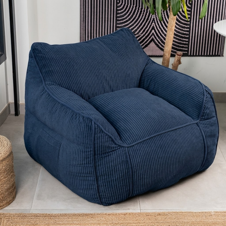 Pouf fauteuil en velours côtelé bleu foncé, forme compacte, assise capitonnée